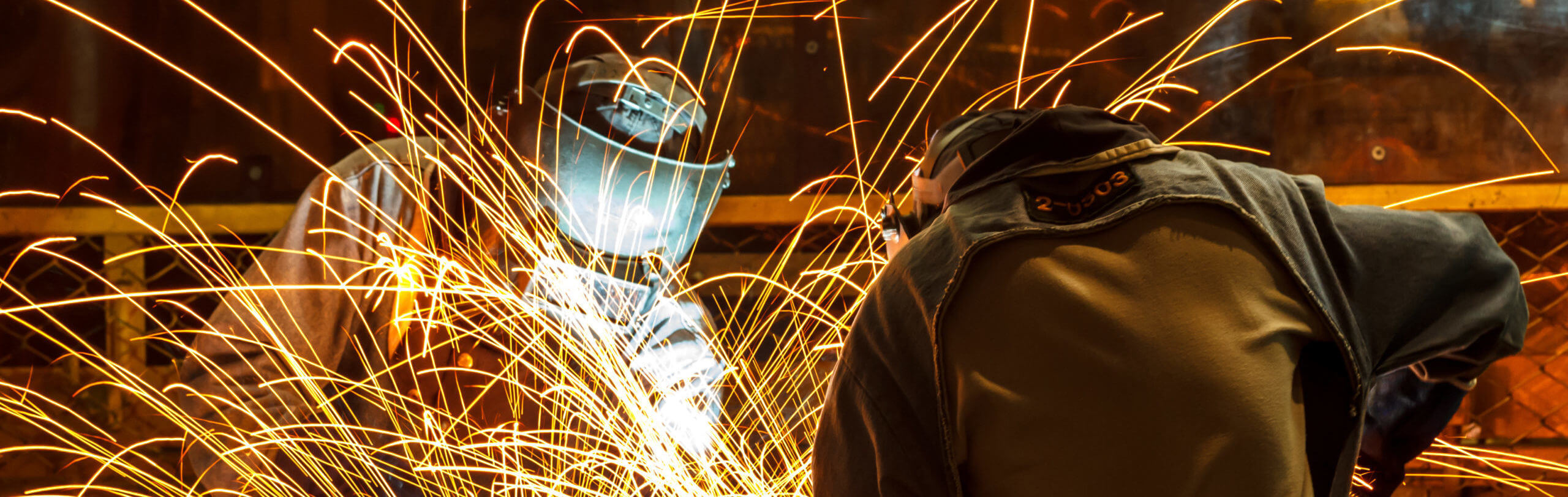 worker with protective mask welding metal
