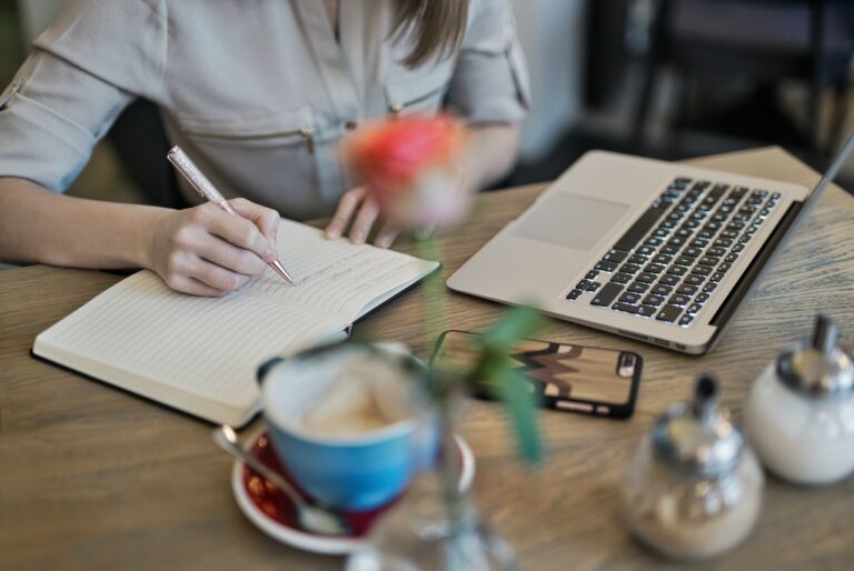 Woman writing down goals to reach full potential