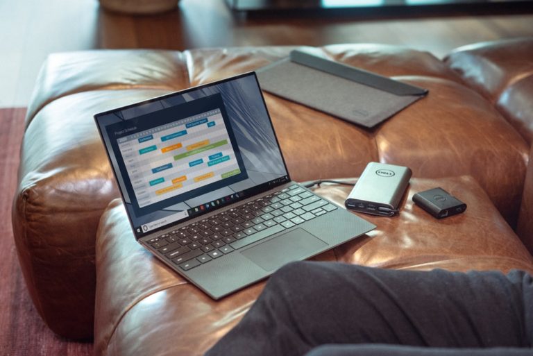 Black and Grey Laptop Resting on Sofa