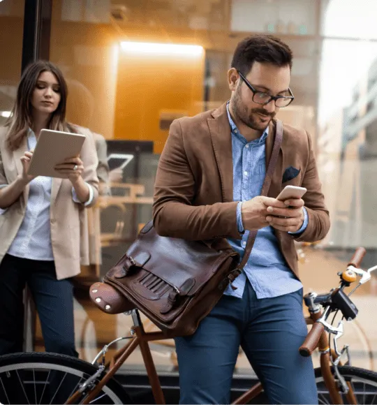 A man walking scrolling on is mobile phone.